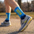 Person wearing blue running socks with 'Boston' text, standing on a path.
