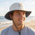 Man wearing a pickleball themed bucket hat on a beach