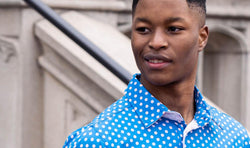 Youth wearing bright blue baseball polo shirt for men featuring a baseball polka dot pattern.