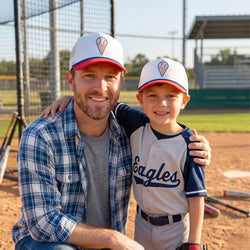 Man and young boy wearing baseball caps on a field