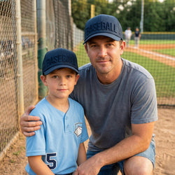 Man and child wearing baseball caps on a baseball field