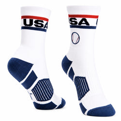 A pair of white crew socks with navy blue and red accents, featuring 'USA' text and a baseball graphic on the cuff, shown against a plain white background.
