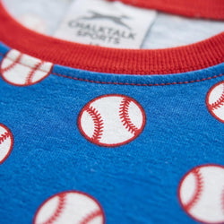 Close-up of a blue children's pajama shirt with a baseball print and red ribbed collar.