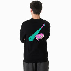 Person wearing a black sweatshirt with a colorful graphic of a baseball bat and donut on the back, standing against a white background
