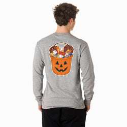 A man viewed from behind wearing a heather gray long-sleeve t-shirt with a large graphic on the back showing a jack-o'-lantern bucket filled with candy, paired with black pants, against a plain white background.