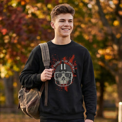 Person wearing a black sweatshirt with a football graphic design, standing outdoors with trees in the background.