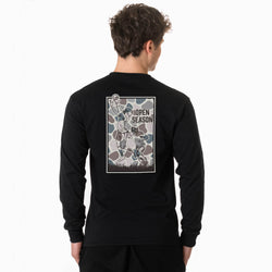 A man viewed from the back wearing a black long-sleeve t-shirt with a large graphic print on the back. The graphic features a vintage-style illustration of football players in a camouflage pattern with the text 'OPEN SEASON'.