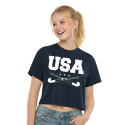 Girl wearing a navy blue t-shirt with 'USA' and field hockey crossed sticks graphic on a white background