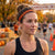 Woman wearing a black shirt and orange turkey headband with a race backdrop