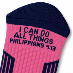 A close-up of a single knit sock in bright pink and navy blue, featuring the text 'I CAN DO ALL THINGS PHILIPPIANS 4:13' knitted in navy on the pink section.