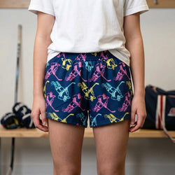 Person wearing colorful shorts with a pattern of a hockey girl on a neutral background