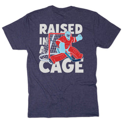 Navy t-shirt with graphic of a hockey goalie and text 'Raised in a Cage' on a white background