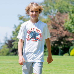 Young boy wearing a white t-shirt with a hockey graphic design outdoors on a sunny day.
