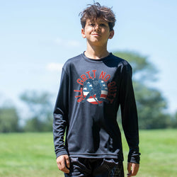 Child wearing a black long-sleeve shirt with text and hockey graphic outdoors