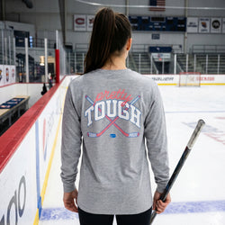 Person wearing a gray long-sleeve shirt with 'Pretty Tough' text on an ice rink.