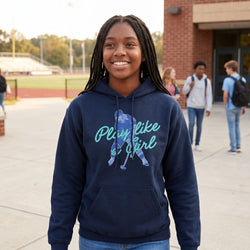 Person wearing a navy hoodie with a hockey girl graphic and text, standing outdoors.