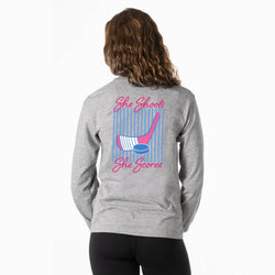 Person wearing a gray long-sleeve shirt with a hockey girl graphic design on the back