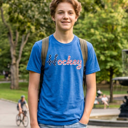Person wearing a blue 'Hockey' t-shirt with a backpack in a park setting