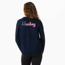 Person wearing a navy sweatshirt with patriotic hockey script design on the back