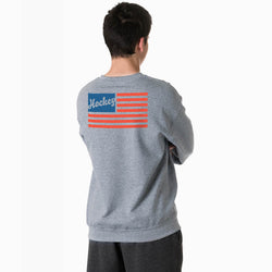 Person wearing a gray sweatshirt with a usa flag design on the back, on a white background