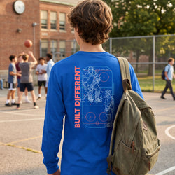 Person wearing a blue shirt with a hockey design and text, standing on a basketball court.