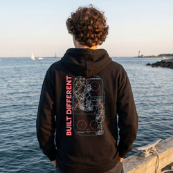 Person wearing a hooded sweatshirt with hockey design at a pier.