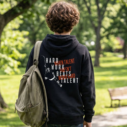 Person wearing a black hoodie with hockey motivational text in a park