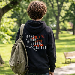 Person wearing a black hoodie with hockey motivational text in a park