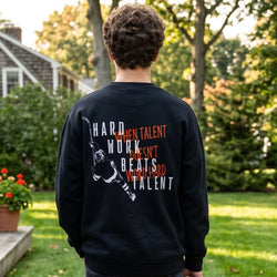 Person wearing a black sweatshirt with 'Hard work beats talent' motivational text on the back.
