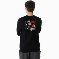 Person wearing a black sweatshirt with text and hockey graphics on the back, standing against a white background