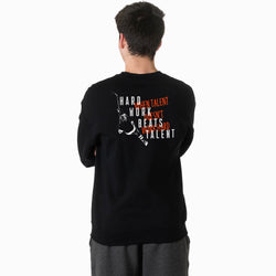 Person wearing a black sweatshirt with text and hockey graphics on the back, standing against a white background