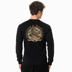 A boy viewed from behind wearing a black long sleeve graphic on the back. The graphic features the words 'DECOYS & DANGLES' in a tan font surrounding a camouflage-patterned circle with a duck and crossed hockey sticks