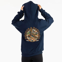 A girl viewed from behind wearing a navy sweatshirt with a large graphic on the back. The graphic features the words 'DECOYS & DANGLES' in a tan font surrounding a camouflage-patterned circle with a duck and crossed hockey sticks
