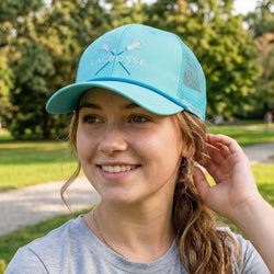 Person wearing a teal lacrosse cap outdoors