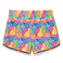 A pair of women's athletic shorts featuring a vibrant, multicolor pattern of stylized lacrosse sticks in pink, blue, green, orange, and purple on a bright yellow background.