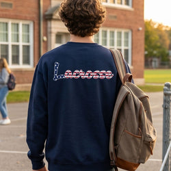 Person wearing a navy blue sweatshirt with 'Lacrosse' on the back, standing in front of a school building.