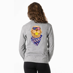 Person wearing a gray sweatshirt with a graphic of a pickleball dog wearing patriotic sunglasses and a bandana on the back.