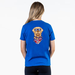 Person wearing a blue t-shirt with a graphic of a soccer dog on the back, on a white background
