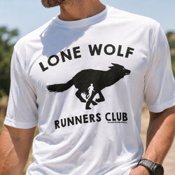A man wearing a white short-sleeve t-shirt with a black graphic print that reads 'LONE WOLF RUNNERS CLUB' with a running wolf silhouette. The photo is taken outdoors in bright natural light.