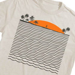 An off-white crewneck t-shirt featuring a graphic print of a beach scene with palm trees, an orange sun, and stylized ocean waves.
