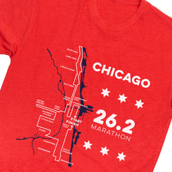 A close-up of a red heather short-sleeve t-shirt featuring a white and navy graphic of the Chicago Marathon map and text.