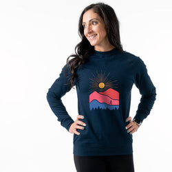 Woman wearing a navy blue sweatshirt with a colorful mountain design on a white background