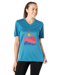 Woman wearing a blue t-shirt with a colorful mountain design on a white background