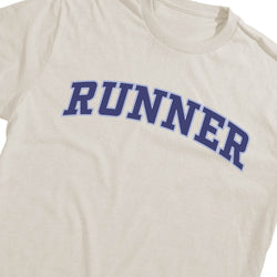 An off-white crewneck t-shirt featuring the word 'RUNNER' printed across the chest in a bold blue varsity-style font with a thin white outline.