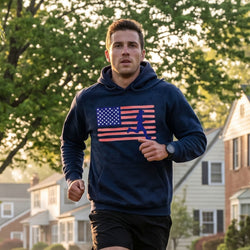 Man running outdoors wearing a hoodie with an American flag design.