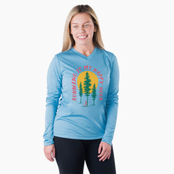 Woman wearing a blue long-sleeve shirt with a nature-themed running design on a white background