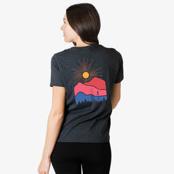 Person wearing a dark gray t-shirt with a colorful graphic on the back, standing against a white background