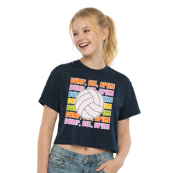 Girl wearing a navy blue t-shirt with colorful volleyball text design on a white background