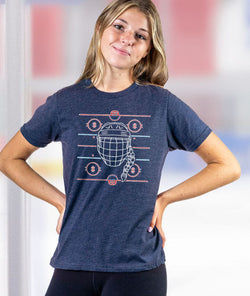Girl wearing a navy girls hockey t-shirt featuring white helmet with braid graphic and ice rink lines
