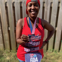 Red tank top with "Land That I Run" text, matching patriotic virtual race medal, and bib
